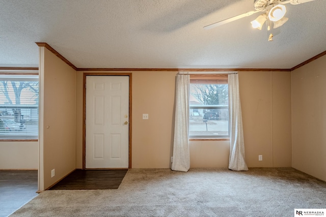 foyer entrance with a wealth of natural light, a textured ceiling, and ceiling fan