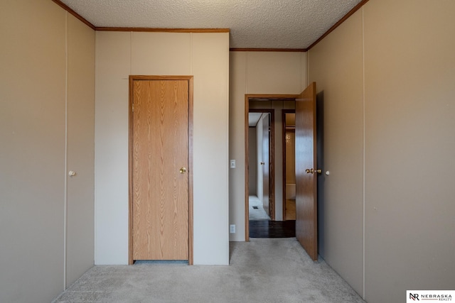 unfurnished bedroom featuring light carpet and a textured ceiling