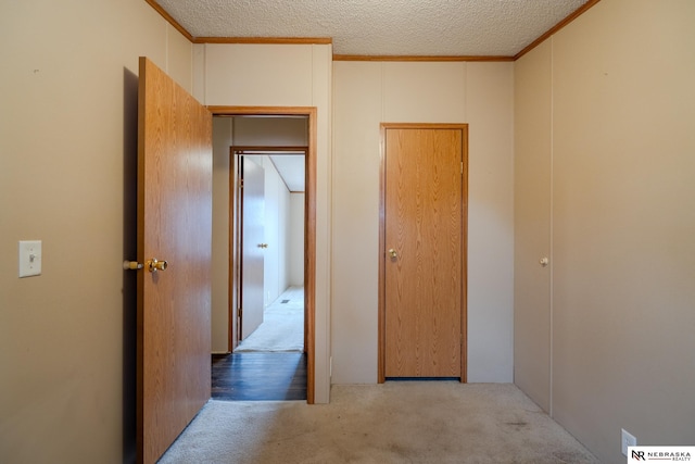 hallway with light carpet and a textured ceiling