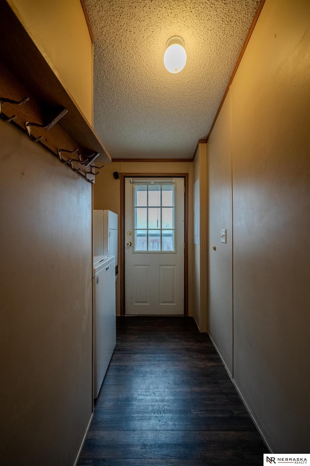 doorway to outside with dark hardwood / wood-style flooring, a textured ceiling, and washer / dryer