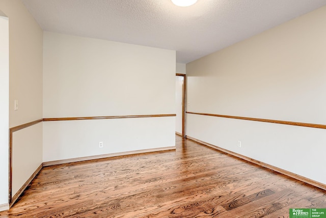 spare room with hardwood / wood-style floors and a textured ceiling