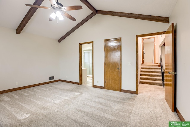 unfurnished bedroom featuring ensuite bathroom, lofted ceiling with beams, light colored carpet, and ceiling fan