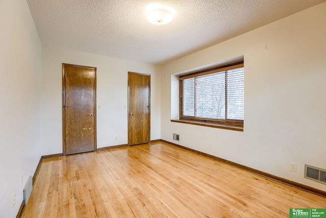 unfurnished bedroom with hardwood / wood-style floors and a textured ceiling