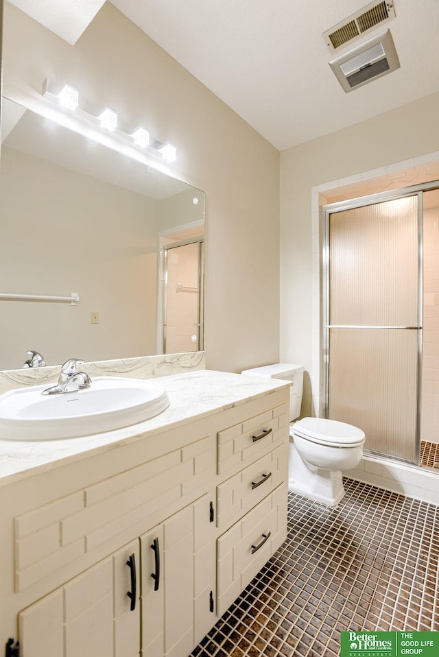 bathroom with tile patterned flooring, vanity, toilet, and an enclosed shower