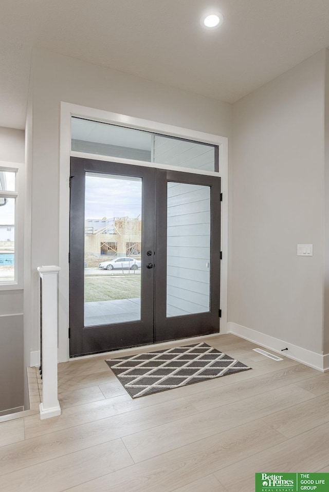 doorway with light wood-type flooring and french doors