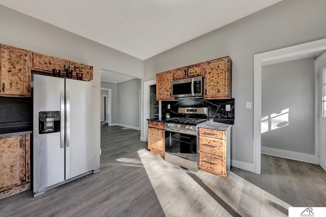 kitchen featuring hardwood / wood-style floors, decorative backsplash, and stainless steel appliances