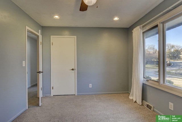 unfurnished room with ceiling fan and light colored carpet