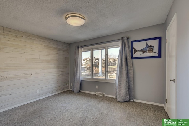 carpeted empty room with a textured ceiling