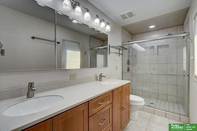 bathroom featuring tile patterned flooring, vanity, toilet, and walk in shower