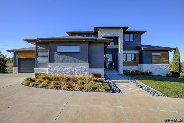 prairie-style home featuring a garage and a front yard