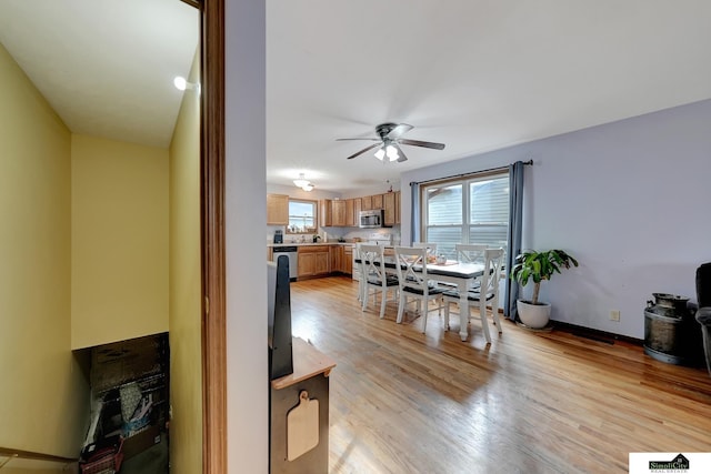 dining room with ceiling fan and light wood-type flooring