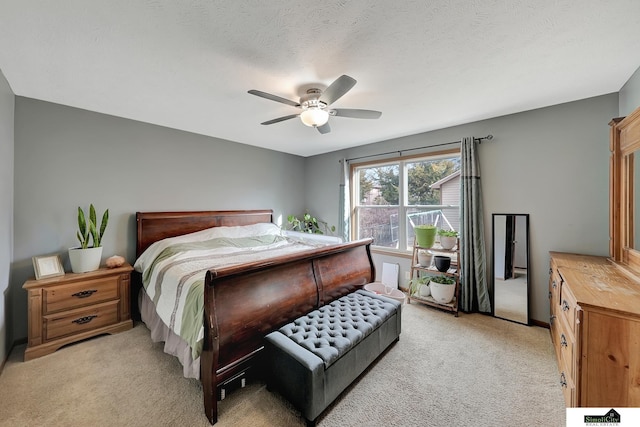 bedroom featuring light carpet, a textured ceiling, and ceiling fan