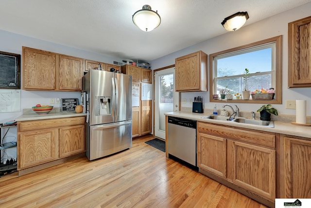 kitchen with light hardwood / wood-style floors, sink, and appliances with stainless steel finishes