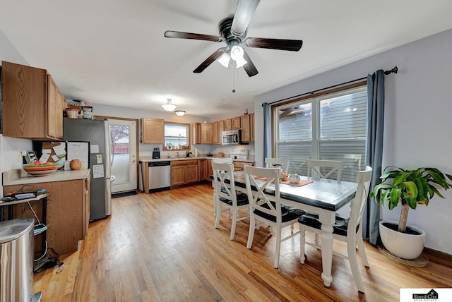 dining space featuring ceiling fan, light hardwood / wood-style floors, and sink