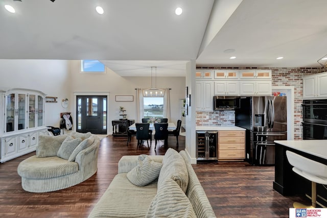 living room featuring dark wood-type flooring, wine cooler, and vaulted ceiling