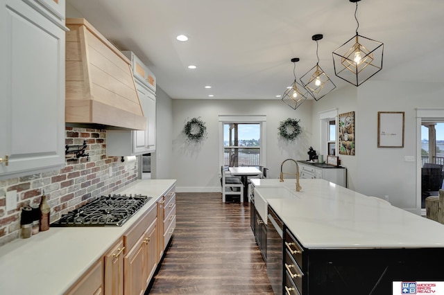 kitchen with white cabinetry, an island with sink, hanging light fixtures, and appliances with stainless steel finishes