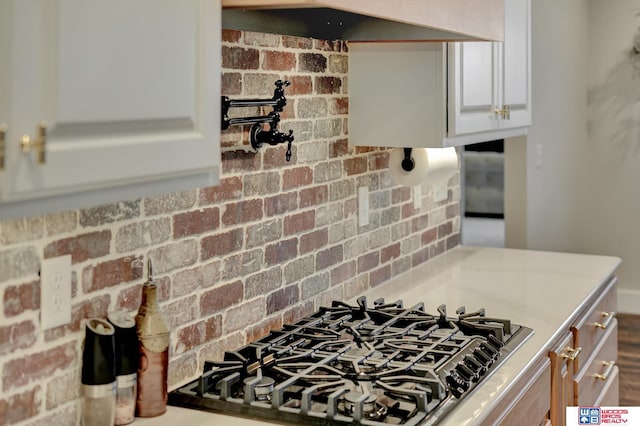 kitchen featuring stainless steel gas stovetop and light stone counters