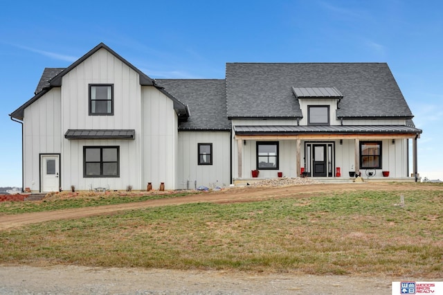 modern farmhouse featuring a front lawn and a porch