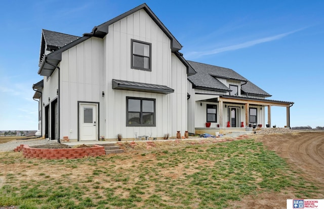 modern farmhouse style home featuring a porch and a front lawn