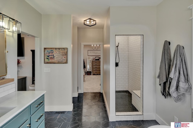 bathroom with tile patterned floors, vanity, and a tile shower