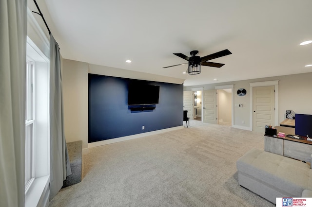 carpeted home theater with ceiling fan