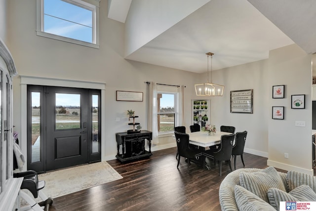 dining space with dark hardwood / wood-style flooring and a notable chandelier