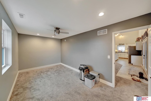 carpeted spare room with ceiling fan