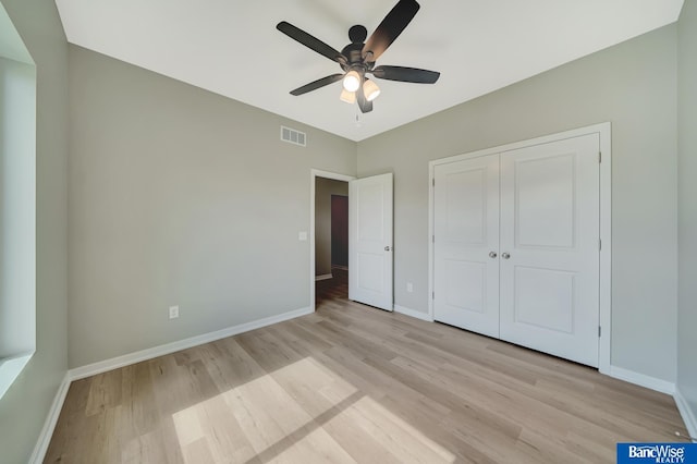 unfurnished bedroom featuring a closet, light hardwood / wood-style flooring, and ceiling fan