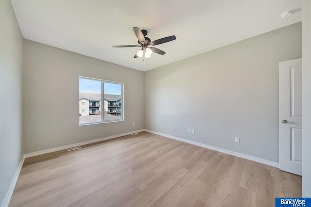 empty room with ceiling fan and light hardwood / wood-style floors