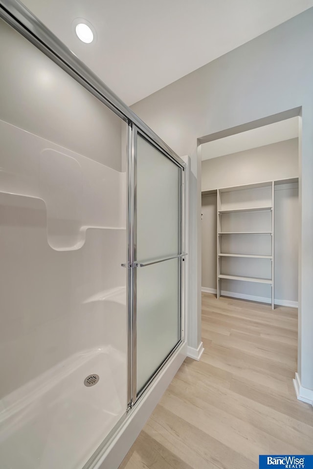 bathroom with hardwood / wood-style flooring and walk in shower