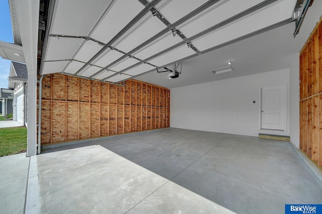 garage with wooden walls and a garage door opener