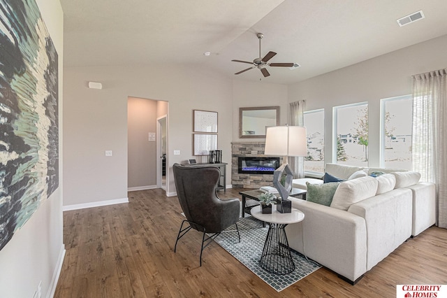 living room with hardwood / wood-style floors, ceiling fan, lofted ceiling, and a fireplace