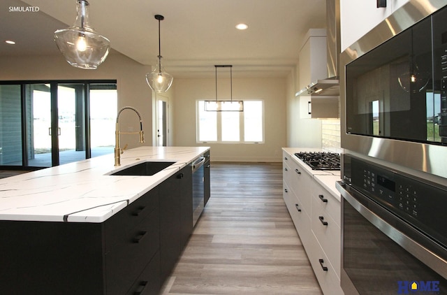 kitchen featuring a spacious island, a sink, white cabinetry, appliances with stainless steel finishes, and dark cabinetry