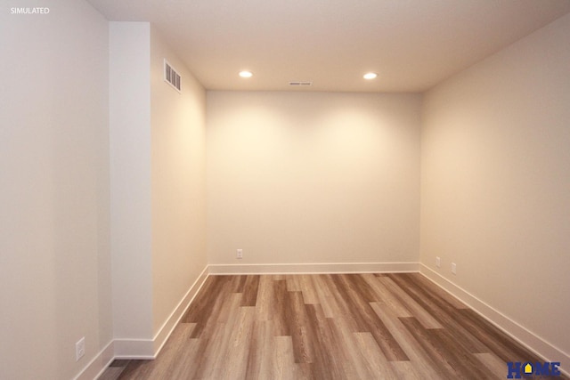 spare room with baseboards, visible vents, wood finished floors, and recessed lighting