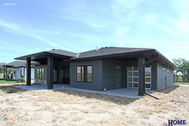 back of property with a patio and a shingled roof