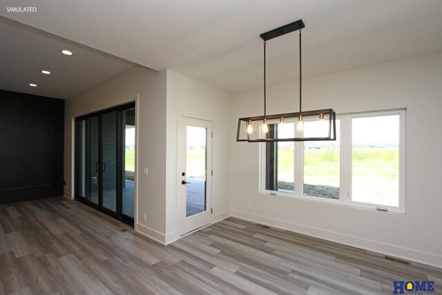 unfurnished dining area with visible vents, baseboards, wood finished floors, and recessed lighting