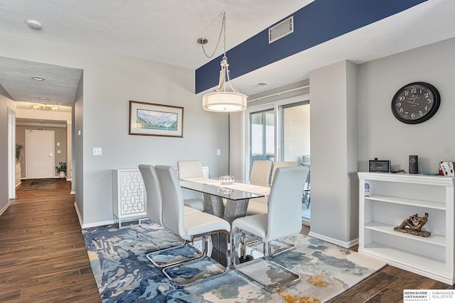 dining area featuring a textured ceiling and dark hardwood / wood-style floors