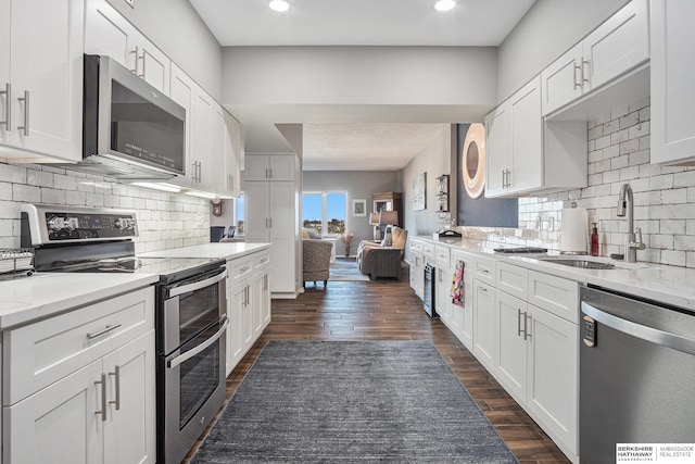 kitchen with white cabinetry, stainless steel appliances, and dark wood-type flooring