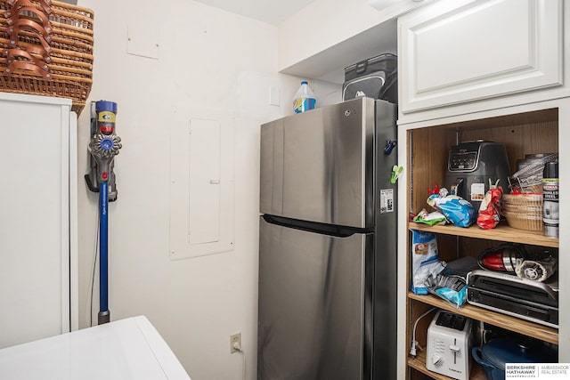 kitchen featuring stainless steel refrigerator and white cabinetry