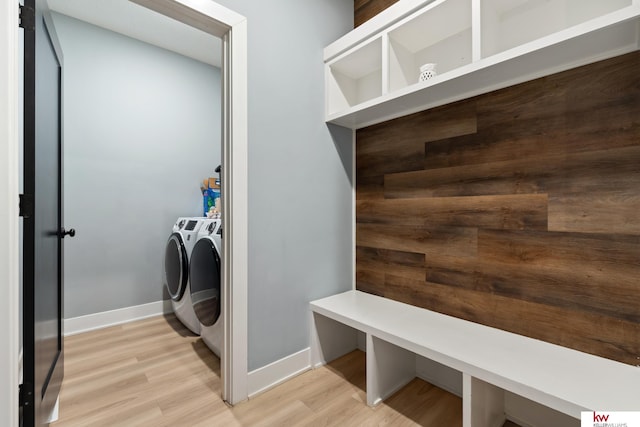 clothes washing area featuring light hardwood / wood-style floors and washing machine and dryer