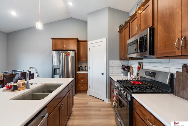 kitchen featuring pendant lighting, lofted ceiling, backsplash, sink, and stainless steel appliances