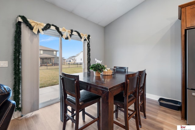 dining room with light hardwood / wood-style floors and lofted ceiling