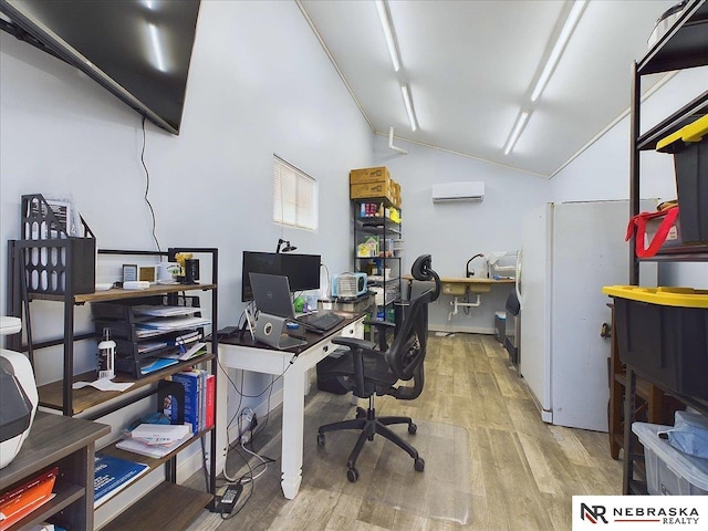 office area with light hardwood / wood-style floors, lofted ceiling, and a wall mounted AC