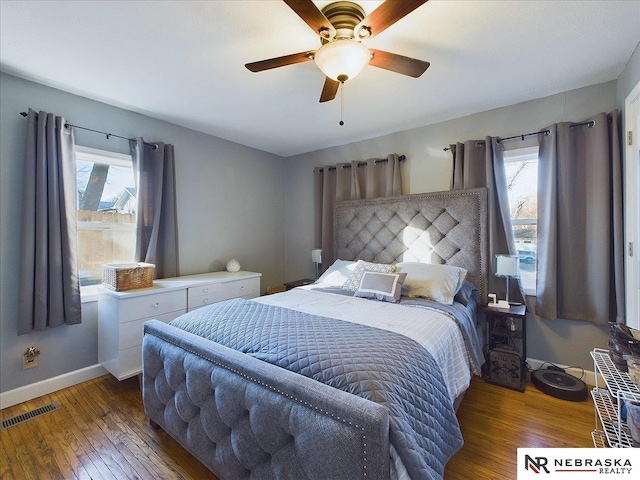 bedroom with dark hardwood / wood-style flooring, multiple windows, and ceiling fan