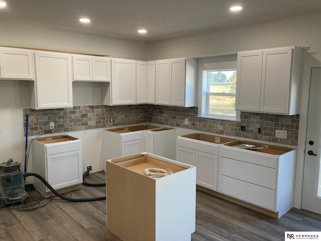 kitchen with wood-type flooring, white cabinetry, and decorative backsplash