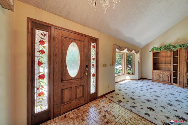 foyer featuring lofted ceiling and a textured ceiling