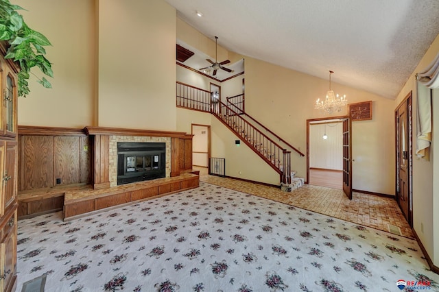 unfurnished living room featuring carpet, ceiling fan with notable chandelier, a textured ceiling, high vaulted ceiling, and a fireplace