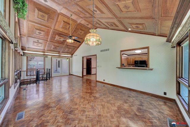 unfurnished living room with ceiling fan, coffered ceiling, parquet flooring, crown molding, and a towering ceiling