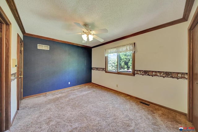 carpeted spare room featuring ceiling fan, crown molding, and a textured ceiling