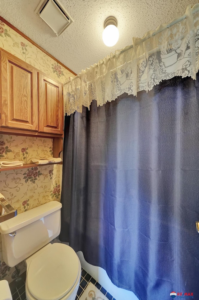 bathroom with tile patterned flooring and toilet